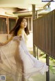 A woman in a long dress standing on a balcony.