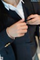 A man in a suit adjusting his cufflinks. 