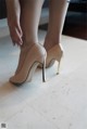 A close up of a woman's legs wearing high heels.