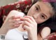 A young girl laying on a couch with her hands on her face.