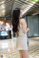 A woman in a white dress standing in an airport.