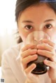 A woman holding a glass of water in her hand.