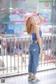 A woman in a pink hat is standing on a balcony.