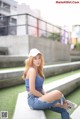 A woman sitting on the ground wearing a white hat.