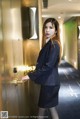 A woman in a business suit standing in an elevator.