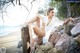 A woman sitting on a rock on the beach.