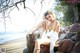 A woman sitting on a rock on the beach.