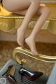 A woman sitting on top of a mirror next to a pair of shoes.