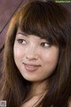 A woman with long brown hair and bangs smiles at the camera.