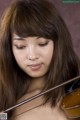 A woman with long brown hair playing a violin.