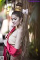 A woman in a traditional thai dress posing for a picture.