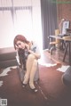 A woman sitting on a chair talking on a cell phone.