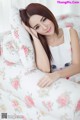 A woman laying on top of a bed with a pillow.