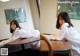 A woman in a white shirt sitting at a table.