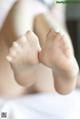 A close up of a woman's bare feet on a bed.