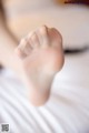 A close up of a person's foot on a bed.