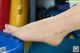 A close up of a woman's feet in a blue bucket.