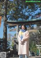 A woman standing in front of a wooden gate.