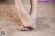 A close up of a person's bare feet on a carpet.