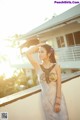 A woman in a long dress standing on a balcony.