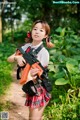 A woman in a school uniform holding a toy gun.