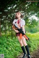 A woman in a school uniform holding a rifle.